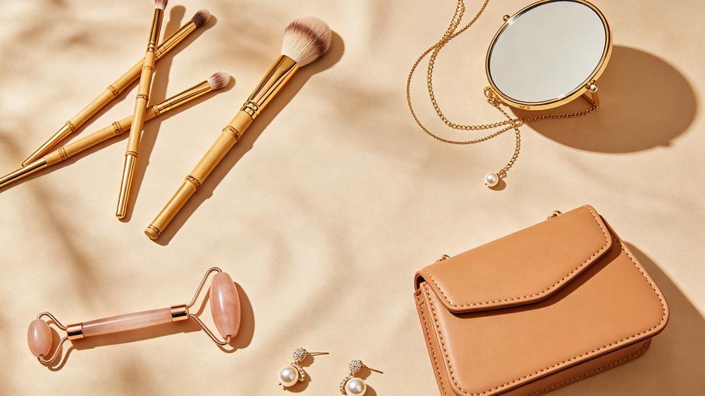 LONYARD women's beauty tools, jewelry and handbags — editorial flat lay